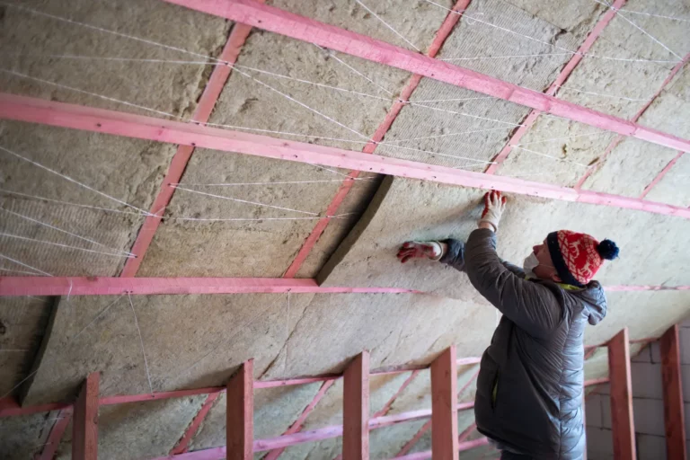 A man insulates an attic and Preventing Respiratory Issues From Upper-Level Insulation