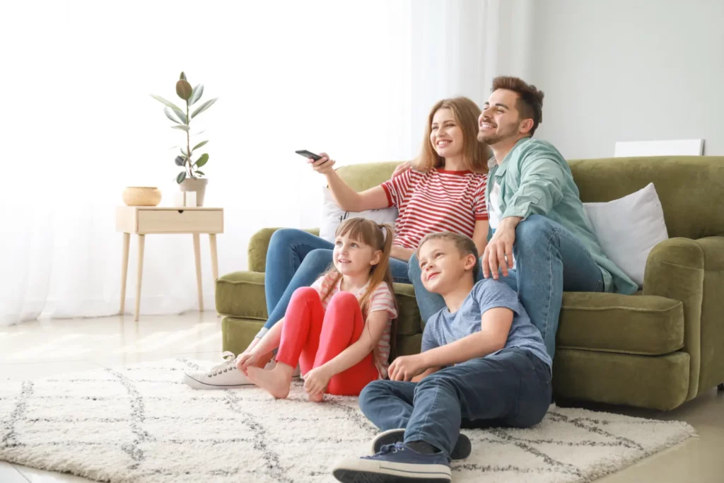 Happy family watching TV at home with expert Home Insulation for a cozy and enjoyable atmosphere.
